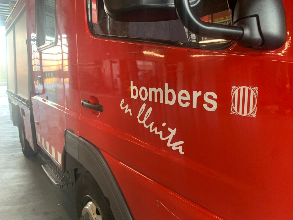 La part davantera d'un camió dels bombers del parc de l'Hospitalet de Llobregat amb la inscripcció 'Bombers en lluita'
