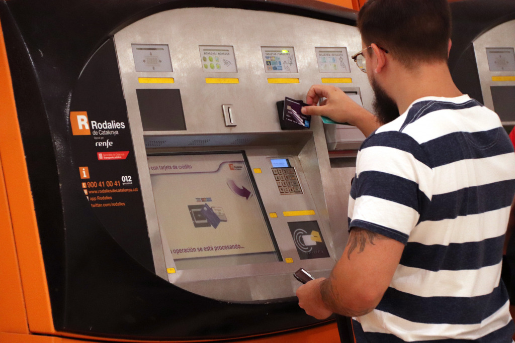 Un noi utilitzat una màquina d'autovenda de bitllets de Rodalies