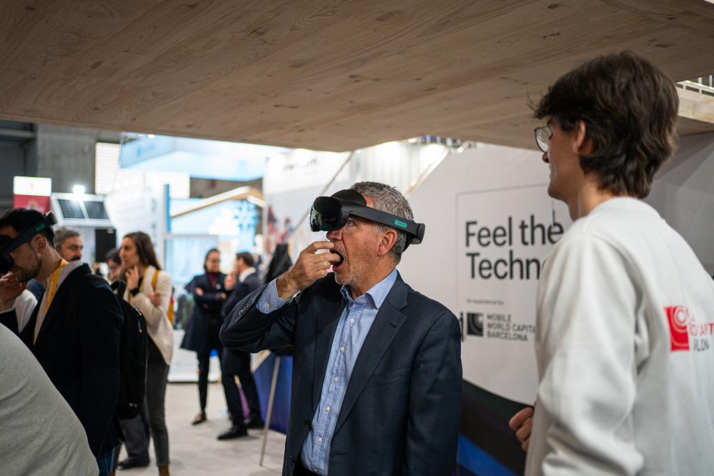 Un visitant menja un bombó dels germans Roca a l'estand del Mobile World Capital 2023.