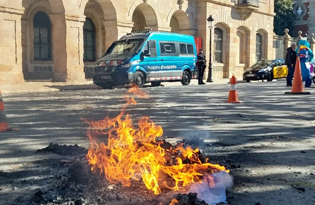 Un cotxe i una foguera davant el Parlament, durant la protesta dels Mossos d'Esquadra el 7 de novembre