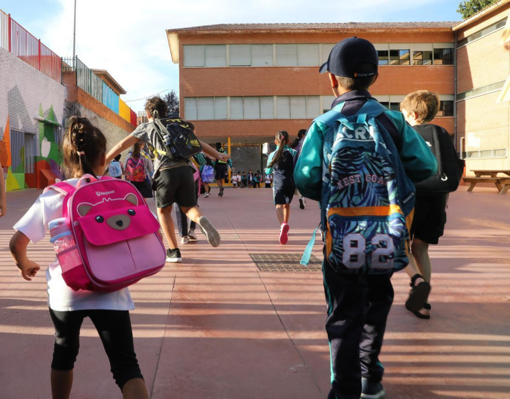 Una nena i un nen entrans a una escola